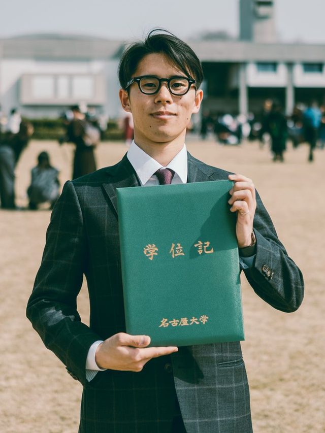 スーツ姿で学位記を持つ武乘至優